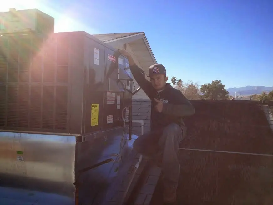 HVAC technician performing Heat Pump Repair on a rooftop unit in Annapolis Neck