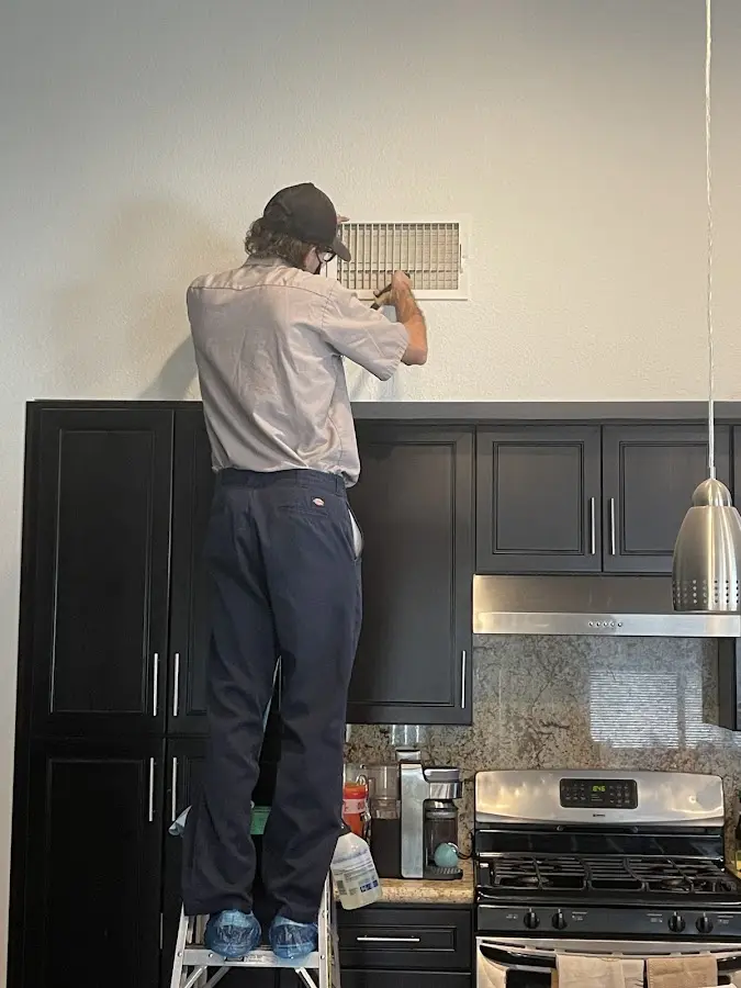 Technician inspecting an air vent during HVAC service in Annapolis Neck